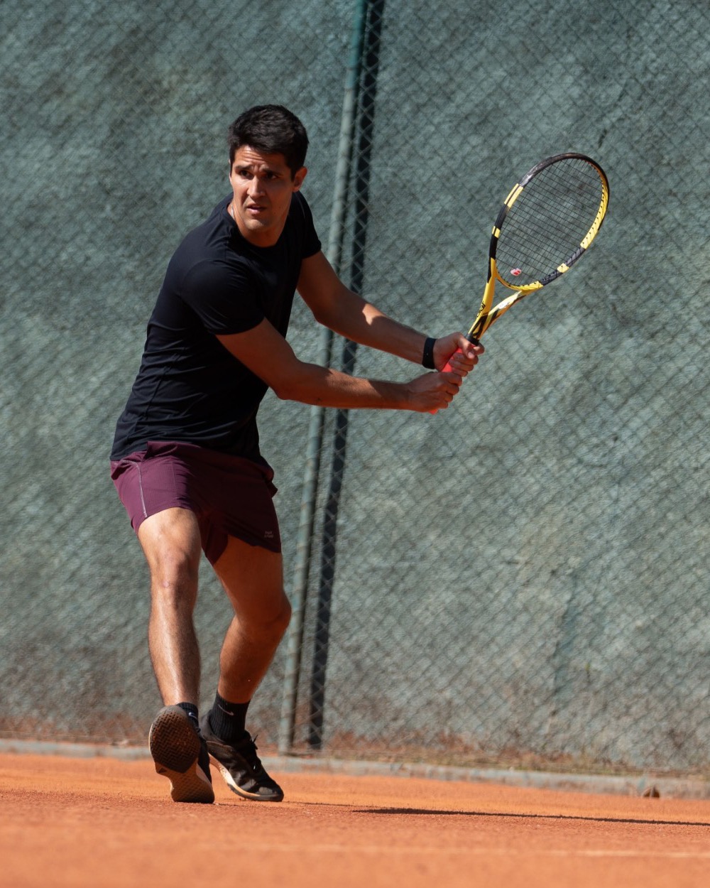Raphael jogando tênis em quadra de saibro